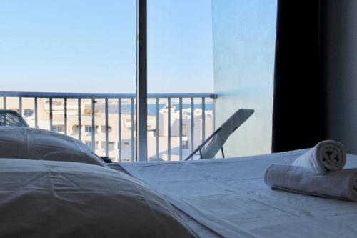 - un lit avec serviettes dans une chambre avec fenêtre dans l'établissement LE SEAVIEW - Studio dernier étage vue mer, plages, à La Grande Motte