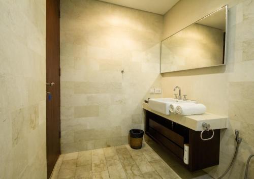 a bathroom with a sink and a mirror at Kuta Ardenia Residence in Kuta