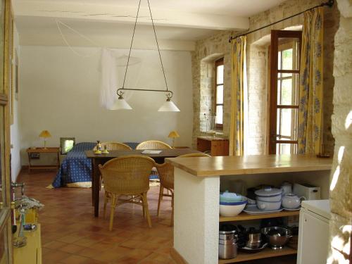 une cuisine et une salle à manger avec une table et des chaises dans l'établissement Ardèche Ferienwohnung, à Le Garn