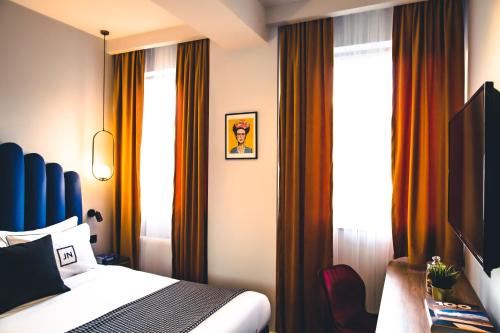 a hotel room with a bed and curtains at JN Boutique Hotel in Bucharest