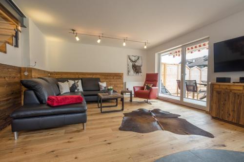 uma sala de estar com um sofá e uma televisão em Ferienwohnung Alpentraum - Griaß di em Obermaiselstein