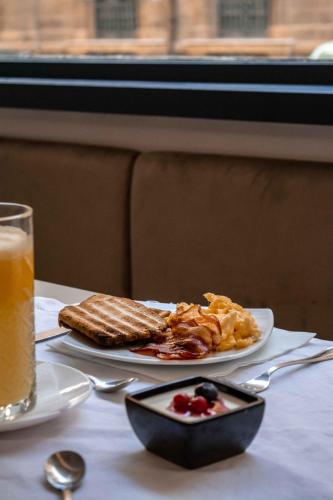 a table with a plate of breakfast food and a drink at Hotel Politeama in Palermo