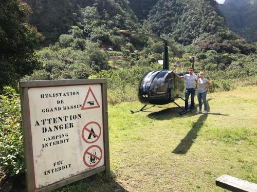 a man and a woman standing next to a helicopter at T2A Lagon Austral "Jardin du lagon" in Saint-Pierre