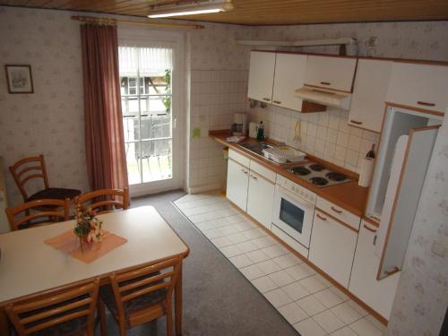 eine Küche mit weißen Geräten sowie einem Tisch und Stühlen in der Unterkunft Feriengut Dietzsch in Pöritzsch
