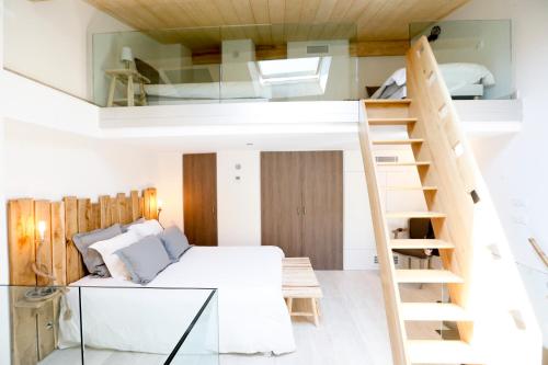 een slaapkamer met een stapelbed en een ladder naar een loft bij La Maison de la Tour in La Tour