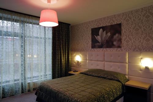1 dormitorio con cama y ventana grande en Loff Hotel, en Yekaterinburg