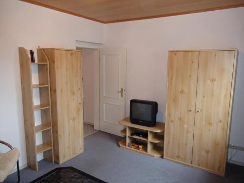 Zimmer mit 2 Holzschränken und einem TV in der Unterkunft Feriengut Dietzsch in Pöritzsch
