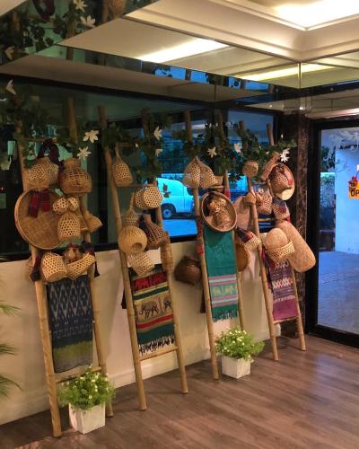 a display of straw hats on chairs in a store at Romance Hotel Sukhumvit 97 in Bangkok