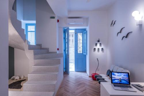 a room with a staircase with a laptop on a desk at Shapes Luxury Suites in Ermoupoli
