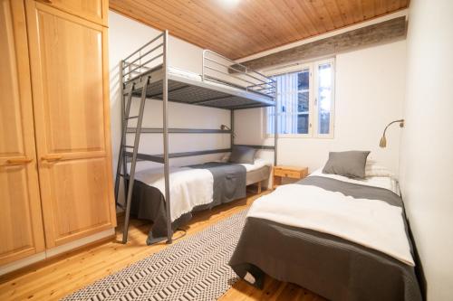 een slaapkamer met 2 bedden en een stapelbed bij Holiday Home Etelärinne E - Ruka Jurmuntie 10 in Kuusamo