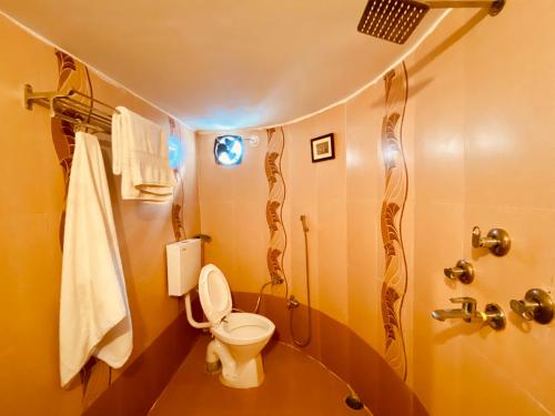 a small bathroom with a toilet and a shower at The Castle View Homestay in Būndi