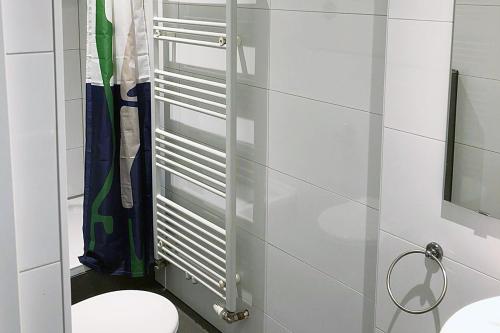 a white bathroom with a toilet and a mirror at cosy three room apartment with flatscreen TV in Recklinghausen
