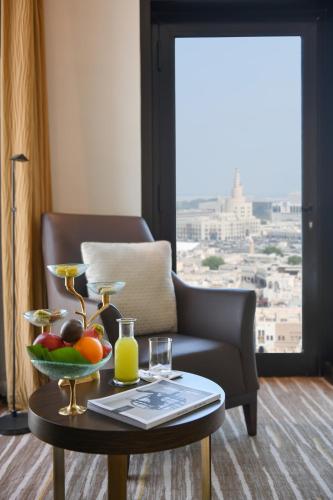 a room with a table with a bowl of fruit on it at Alwadi Hotel Doha - MGallery Collection in Doha