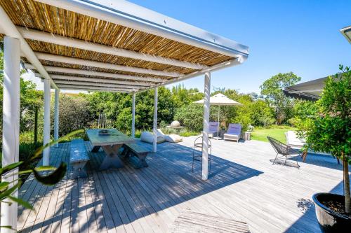 a patio with a table and a wooden deck at Oude Berg Guesthouse - 10 Caledon Street in George