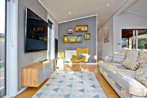 a living room with a couch and a table at Nyland Lodge - Hot Tub - Fireplace - Free Parking & WiFi in Cheddar