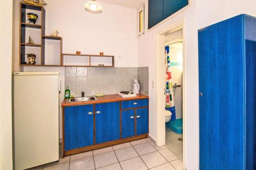 una cucina con armadi blu e lavandino di Villa Panorama a Keríon