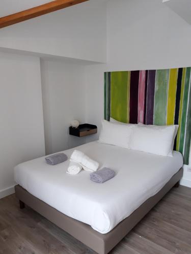 a white bed with two towels on top of it at L'Expression in Saint-Jean-de-Marsacq