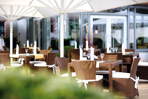 an empty restaurant with tables and chairs and umbrellas at Schloss Reinach in Freiburg im Breisgau