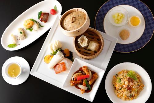 a table with plates of food and bowls of food at Hotel New Otani Tokyo EXECUTIVE HOUSE ZEN in Tokyo