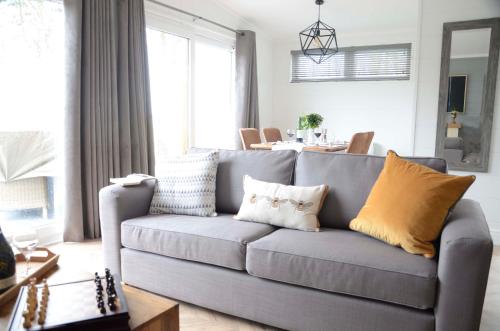 a living room with a gray couch with yellow pillows at Hollicarrs - Honeycomb Lodge in York