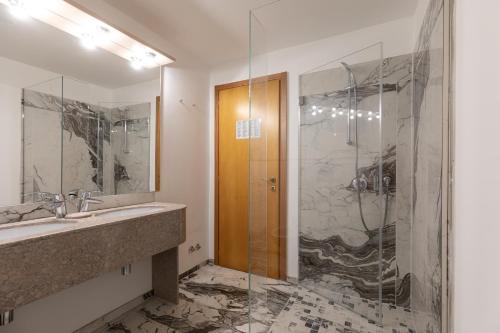 卡瓦利諾－特雷波爾蒂的住宿－卡瓦利諾比安科酒店，一间带水槽和玻璃淋浴的浴室