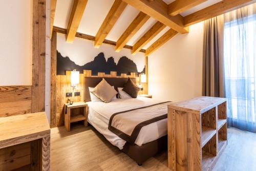 a bedroom with a bed in a room at Lady Maria Hotel Wellness & Resort in Fondo