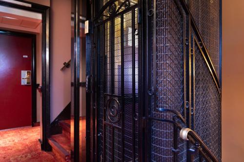an iron gate in a hallway with a red door at Elysées Hôtel in Paris