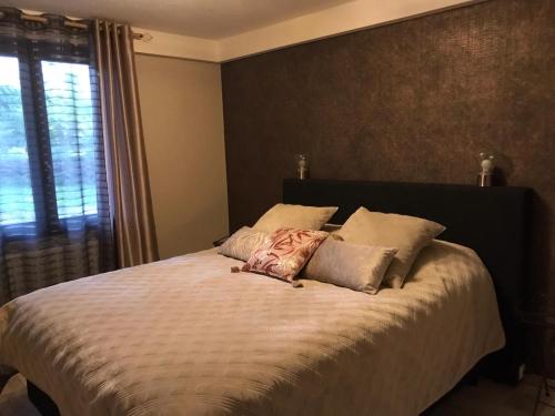 um quarto com uma cama com almofadas e uma janela em Atelier des Rêves em Vichy