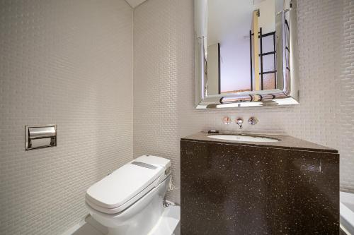 a bathroom with a toilet and a sink and a mirror at Hotel The Designers Kondae in Seoul