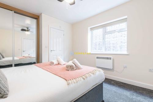 a bedroom with a large bed and a window at 2 BED Modern apartment. Close to station & PARKING in Slough