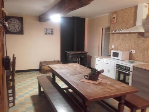 a kitchen with a wooden table and a counter top at domaine de crayeux in Les Champs