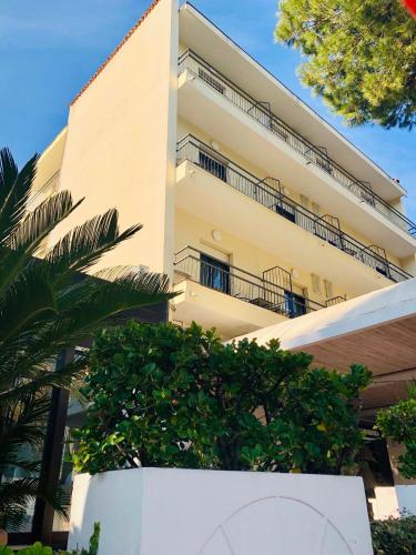an apartment building with trees in front of it at Hotel Garisenda B&B - in Centro a Riccione - in Riccione