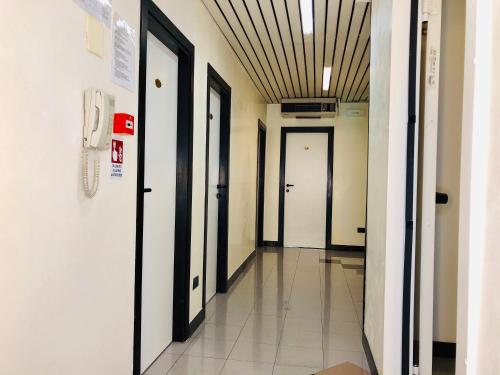 a hallway of a hospital with doors and a phone at Hotel Garisenda B&B - in Centro a Riccione - in Riccione