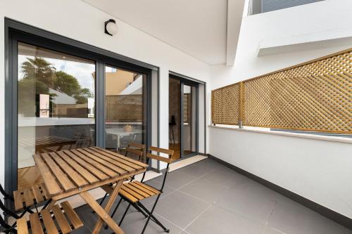 a balcony with a wooden table and chairs at Belem Design Apartments by Homing in Lisbon