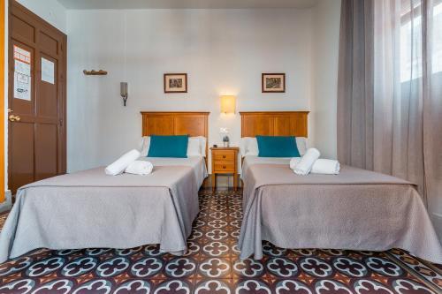 Habitación con 2 camas y almohadas azules. en Veronica Centro, en Granada