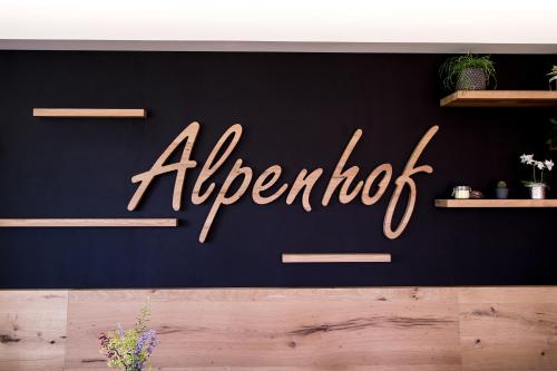 a sign that reads albertoit on a black wall at Alpenhof in Ramsau am Dachstein