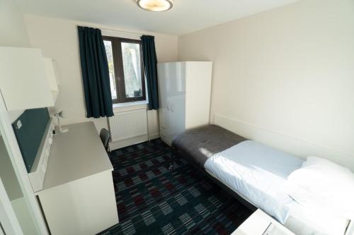 a hotel room with a bed and a television at Pollock Estate - Summer Accommodation in Edinburgh