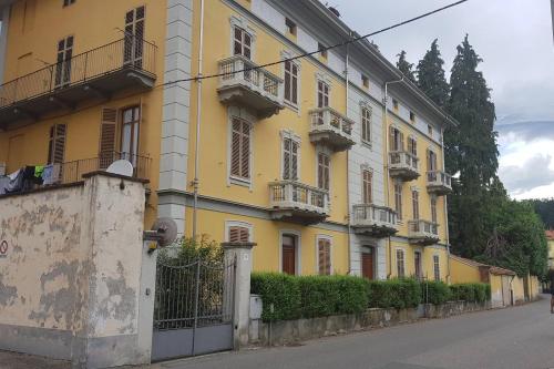 a yellow building with balconies on a street at Ca di Biella in Biella