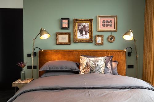 a bedroom with a bed with four pictures on the wall at Stella Suites Boutique Hotel in Goirle