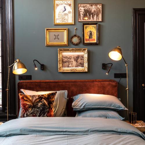 a bedroom with a bed and framed pictures on the wall at Stella Suites Boutique Hotel in Goirle