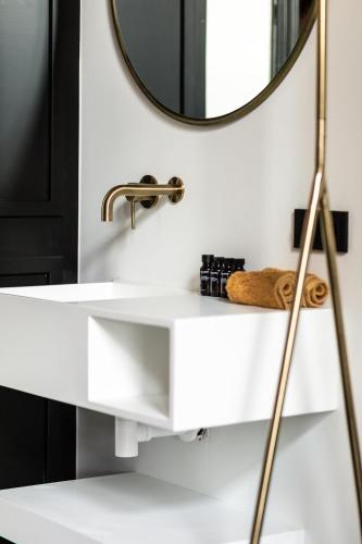a bathroom with a white sink and a mirror at Stella Suites Boutique Hotel in Goirle