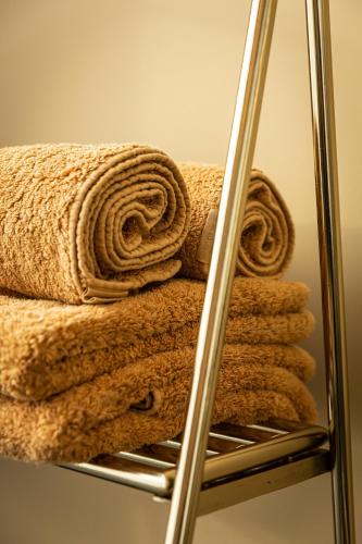 a pile of towels on a towel rack at Stella Suites Boutique Hotel in Goirle
