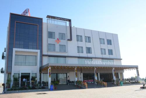 NarodaにあるHotel Darshan SP Ring Roadの赤い星が描かれた白い大きな建物