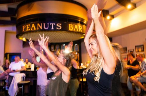 a group of women standing in a bar with their hands in the air at Three Corners Fayrouz Plaza Beach Resort in Port Ghalib