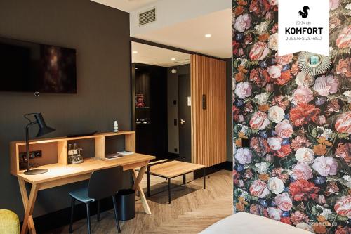 a room with a desk and a wall with flowers at WunnersWat Verl in Verl