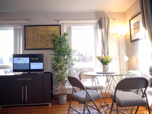 a living room with a table and chairs and a television at Perfect Central City Location - Parking - 4 Beds - 2 Bedrooms in Belfast