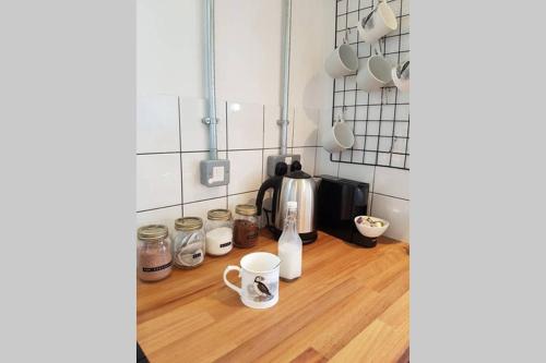 a kitchen with a counter with cups and a coffee maker at Milking Shed Cottage in Narberth