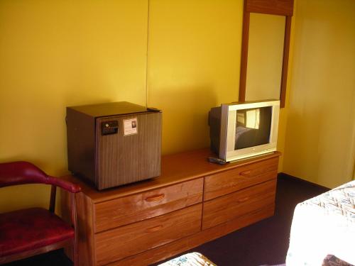 a tv on top of a dresser with a television on it at Hollywood Motel in Kenova