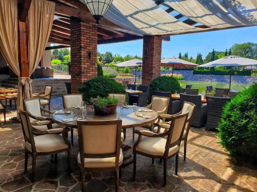 a patio with a table and chairs and an umbrella at Park Hotel Popovicky in Popovičky