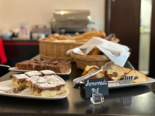 a table with three plates of bread and pastries at Red & Blue Design Hotel Prague in Prague
